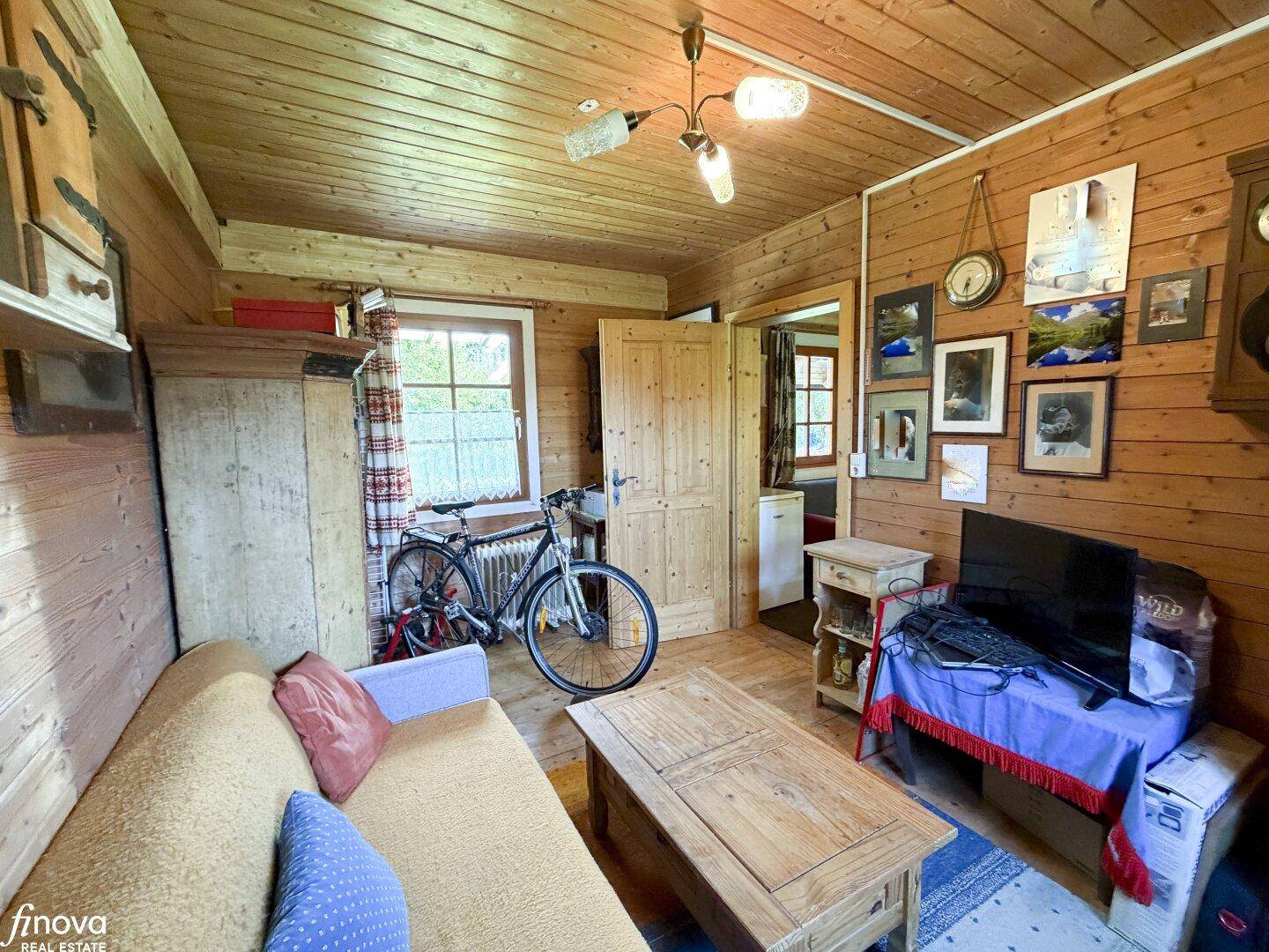 Gemütliches Wohnzimmer mit Holzvertäfelung, Sofa und traditioneller Einrichtung.