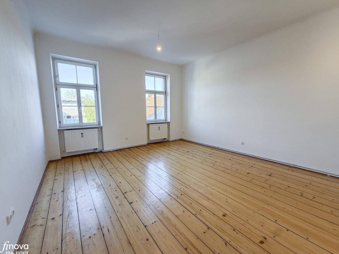 Großes, helles Zimmer mit breiten Dielenböden und zwei Fenstern, bietet vielseitige Nutzungsmöglichkeiten.