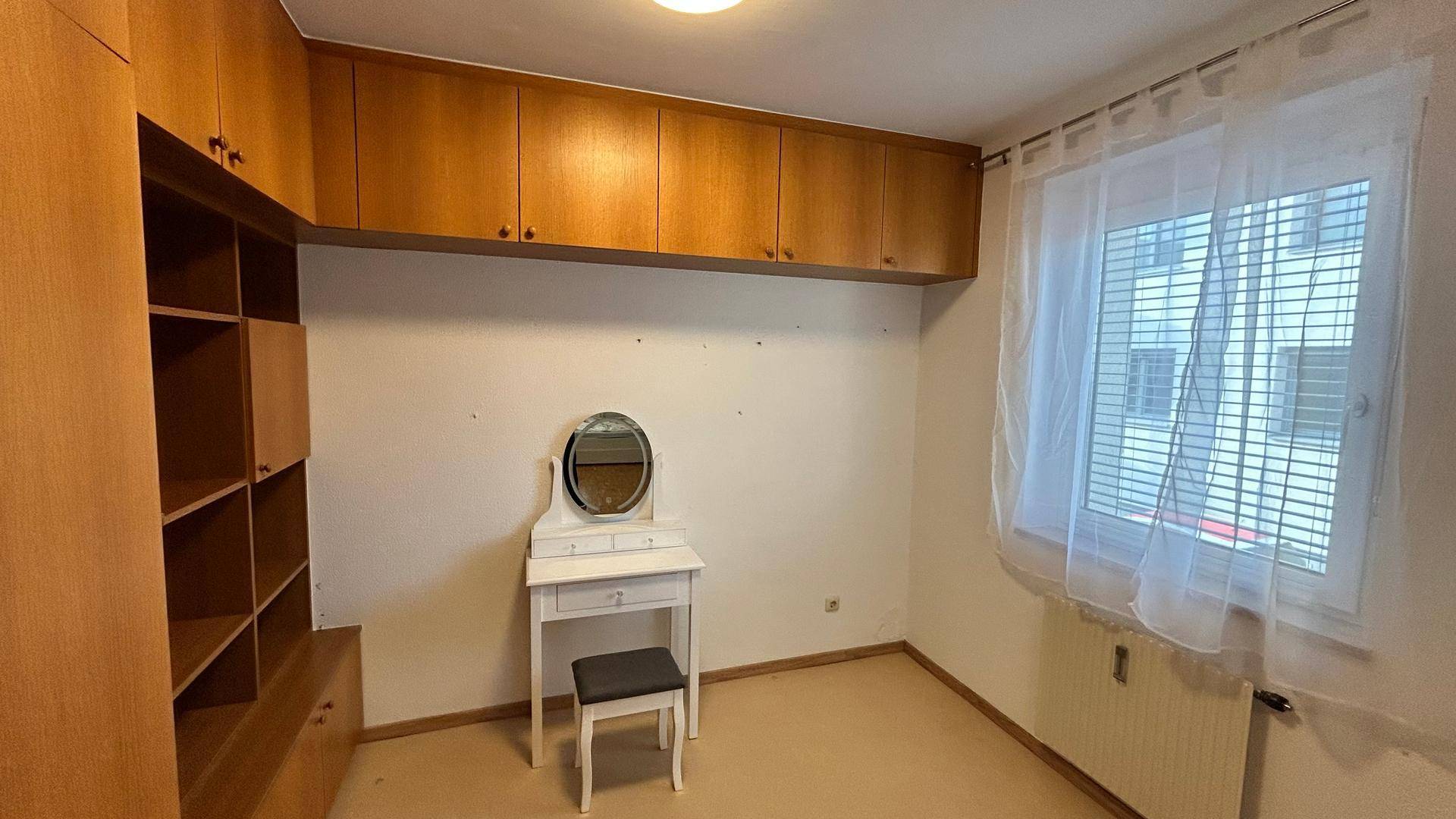 Kleines Schlafzimmer oder Ankleidezimmer mit Einbauschränken und Schminktisch.