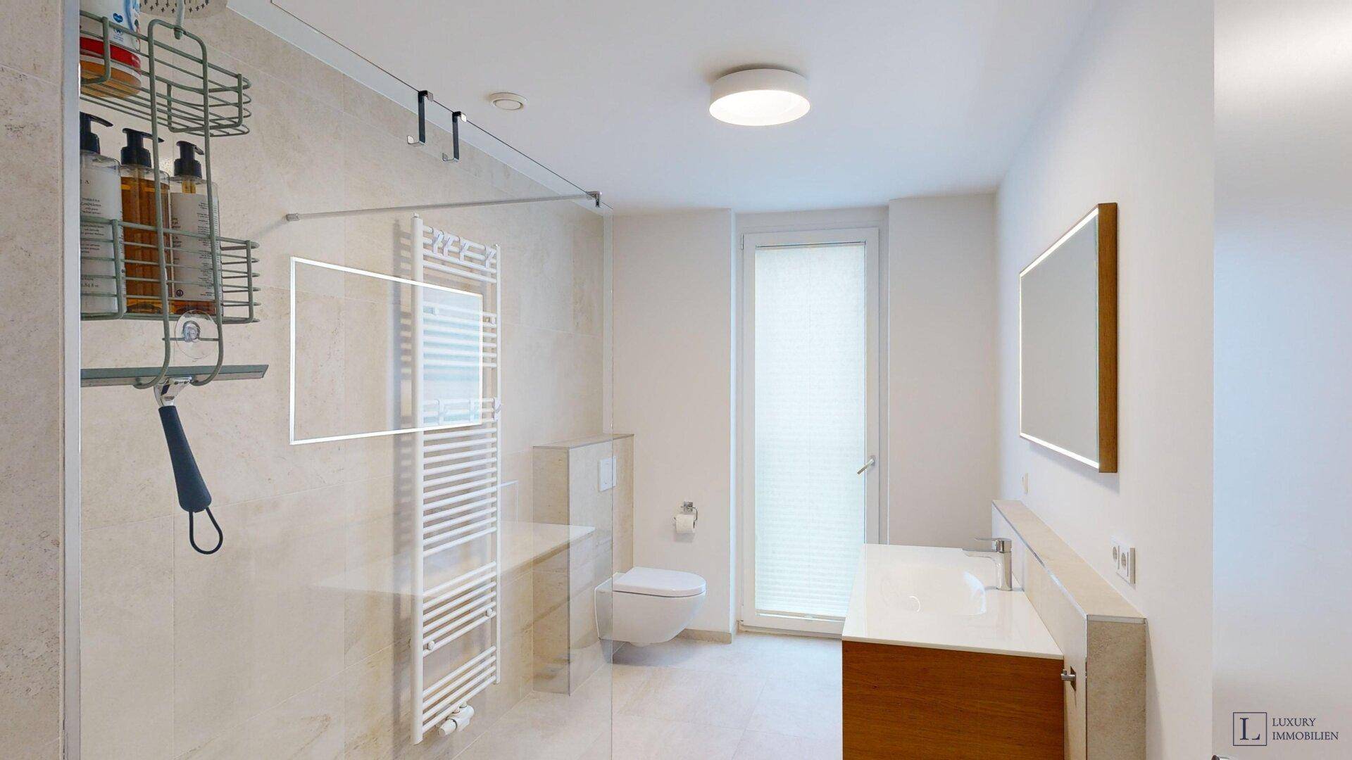 Helles Badezimmer mit begehbarer Dusche, WC und Fenster für Tageslicht.