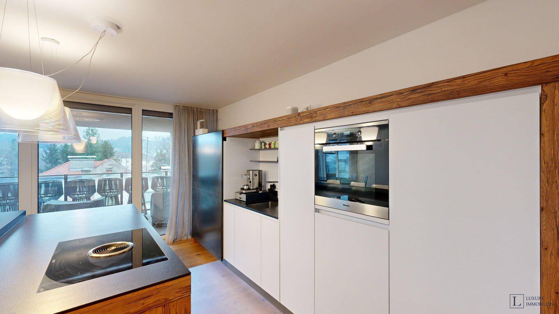 Moderne Einbauküche mit integriertem Backofen, Kochinsel und Holzakzenten.