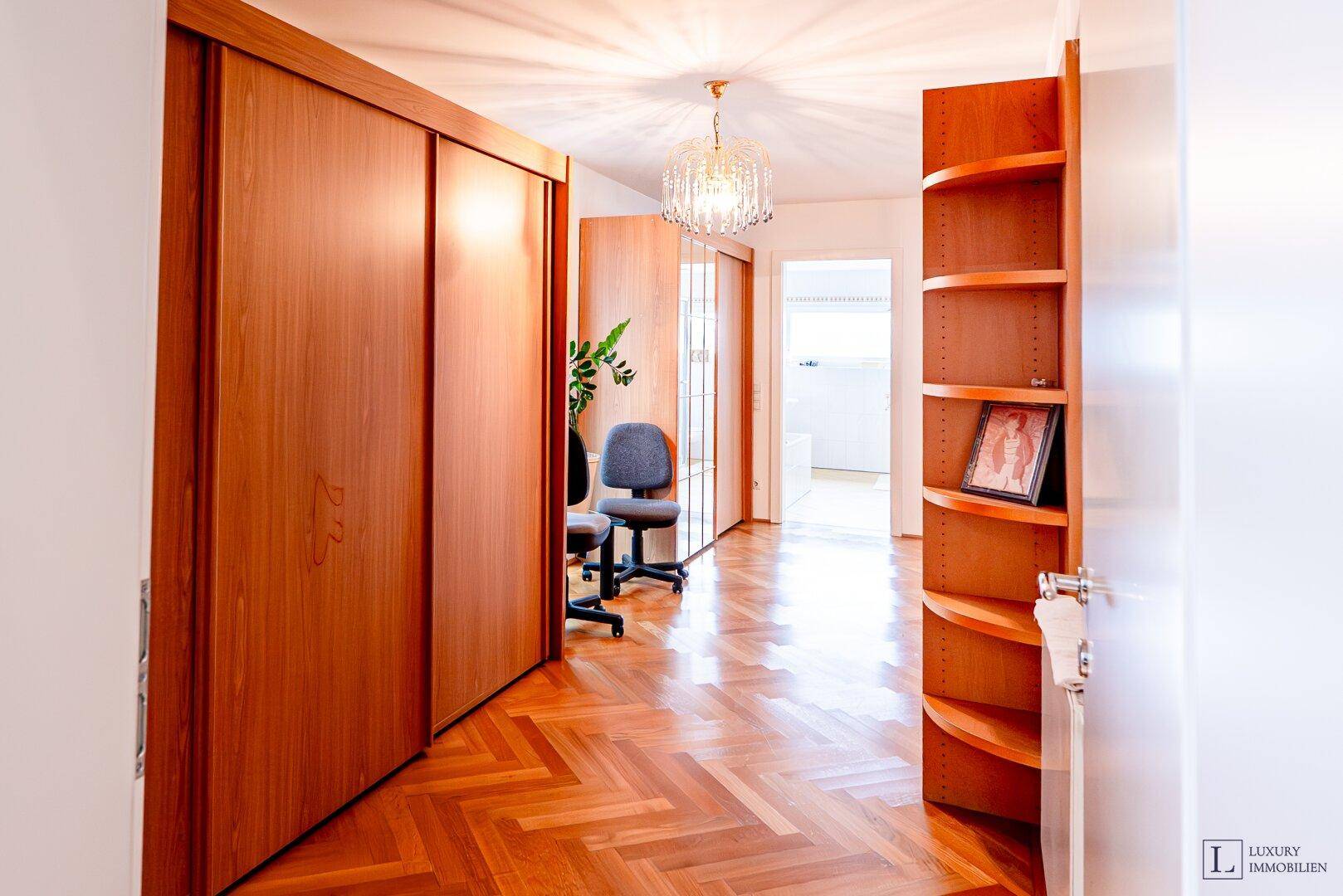 Langer Flur mit Holzschränken, Regalen und Blick in weitere Räume.