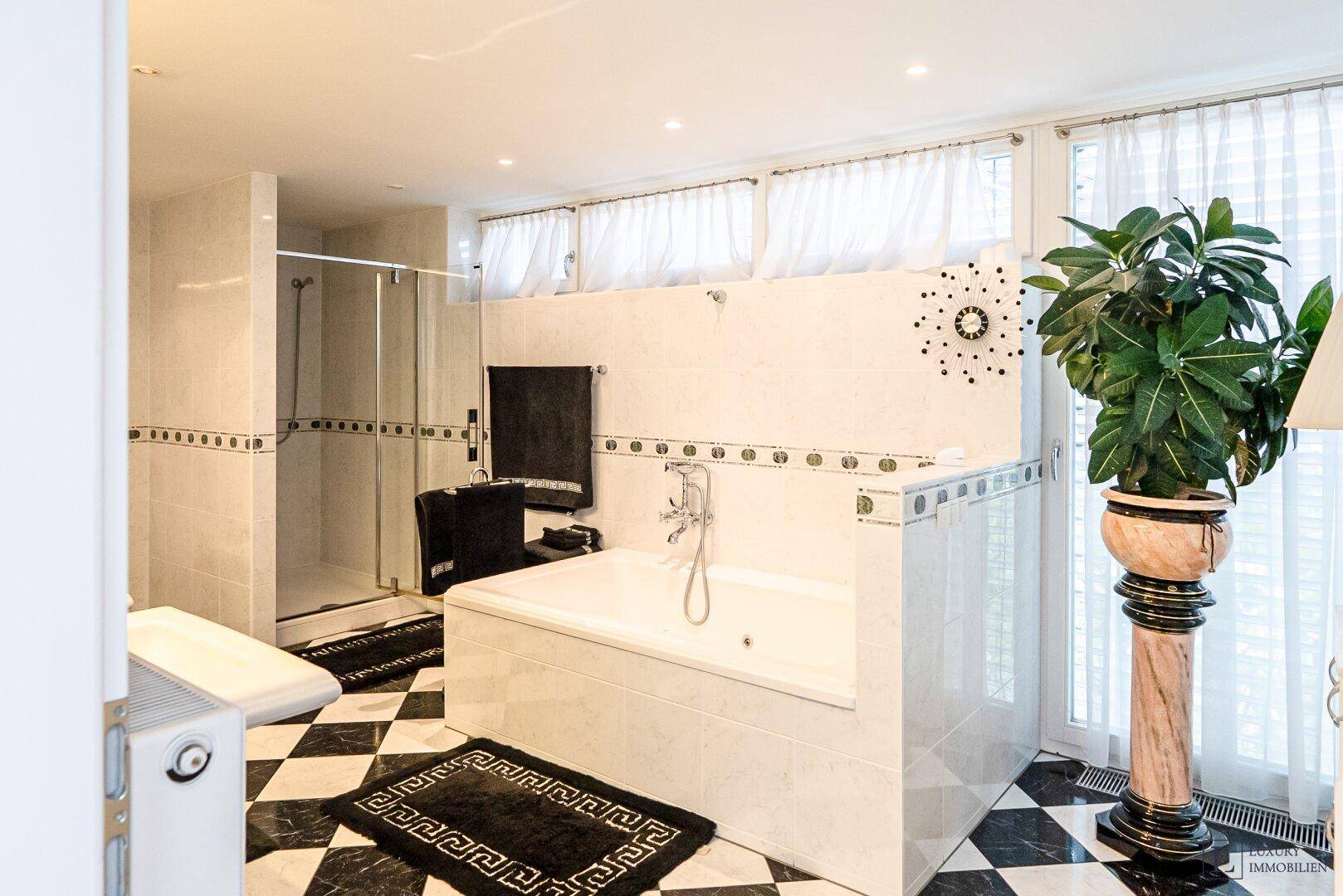 Helles Badezimmer mit Badewanne, Dusche und Fenster für natürliche Belüftung.