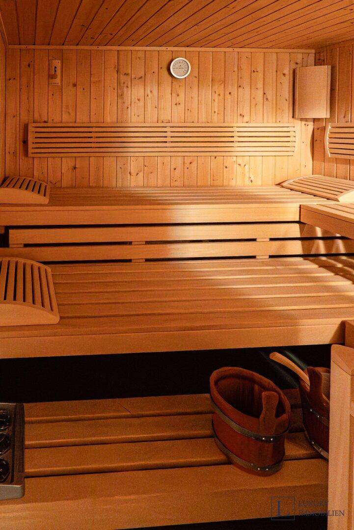 Traditionelle Holzsauna mit Bänken und Heizofen für entspannende Momente.