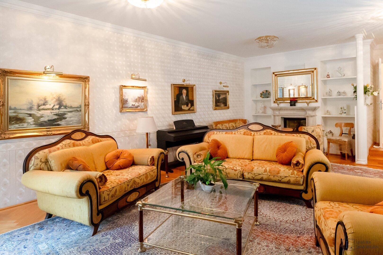 Elegantes Wohnzimmer mit beigen Sofas, Teppich und klassischer Dekoration.