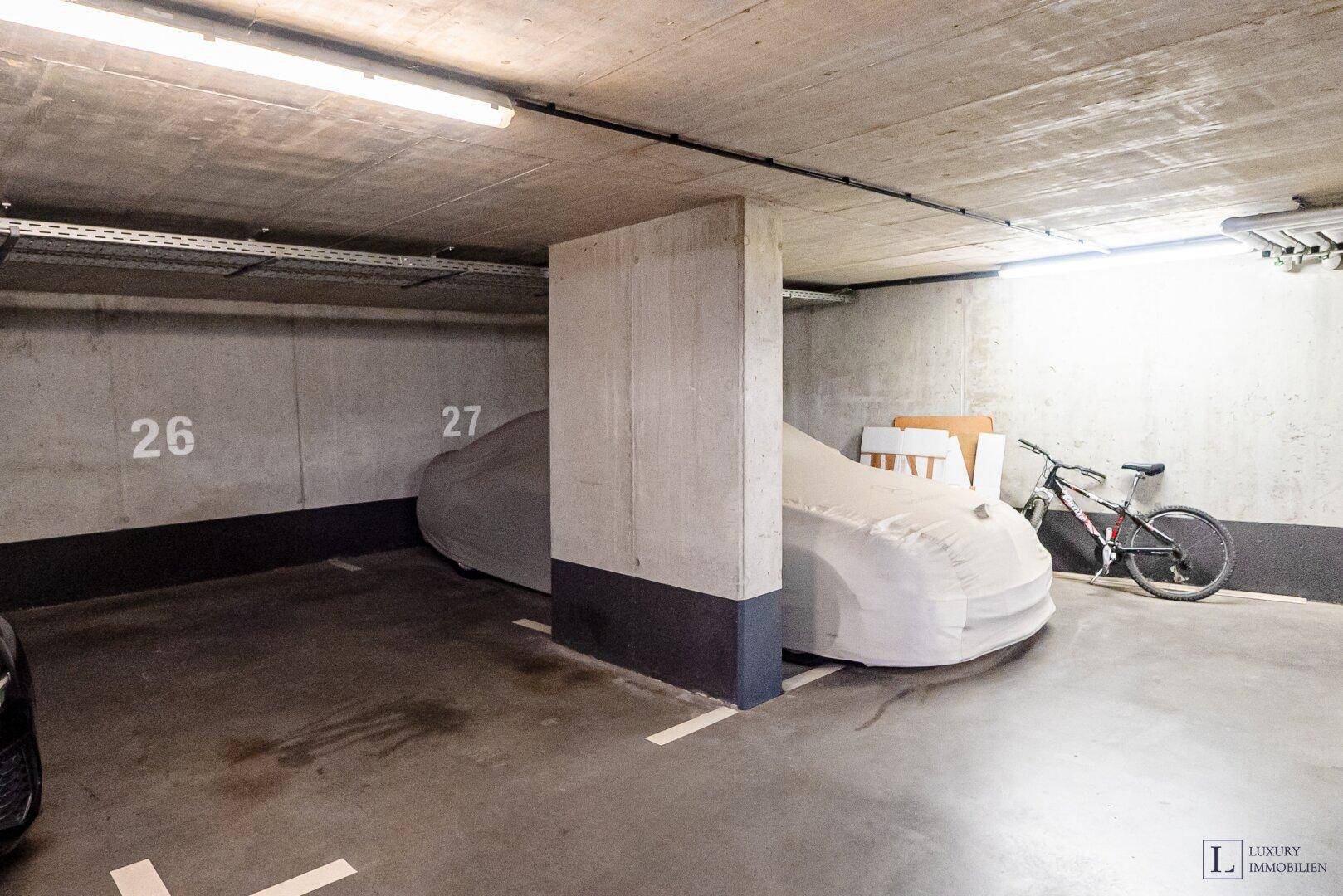 Tiefgarage mit markierten Stellplätzen und Fahrrädern, bietet sicheren Parkraum.
