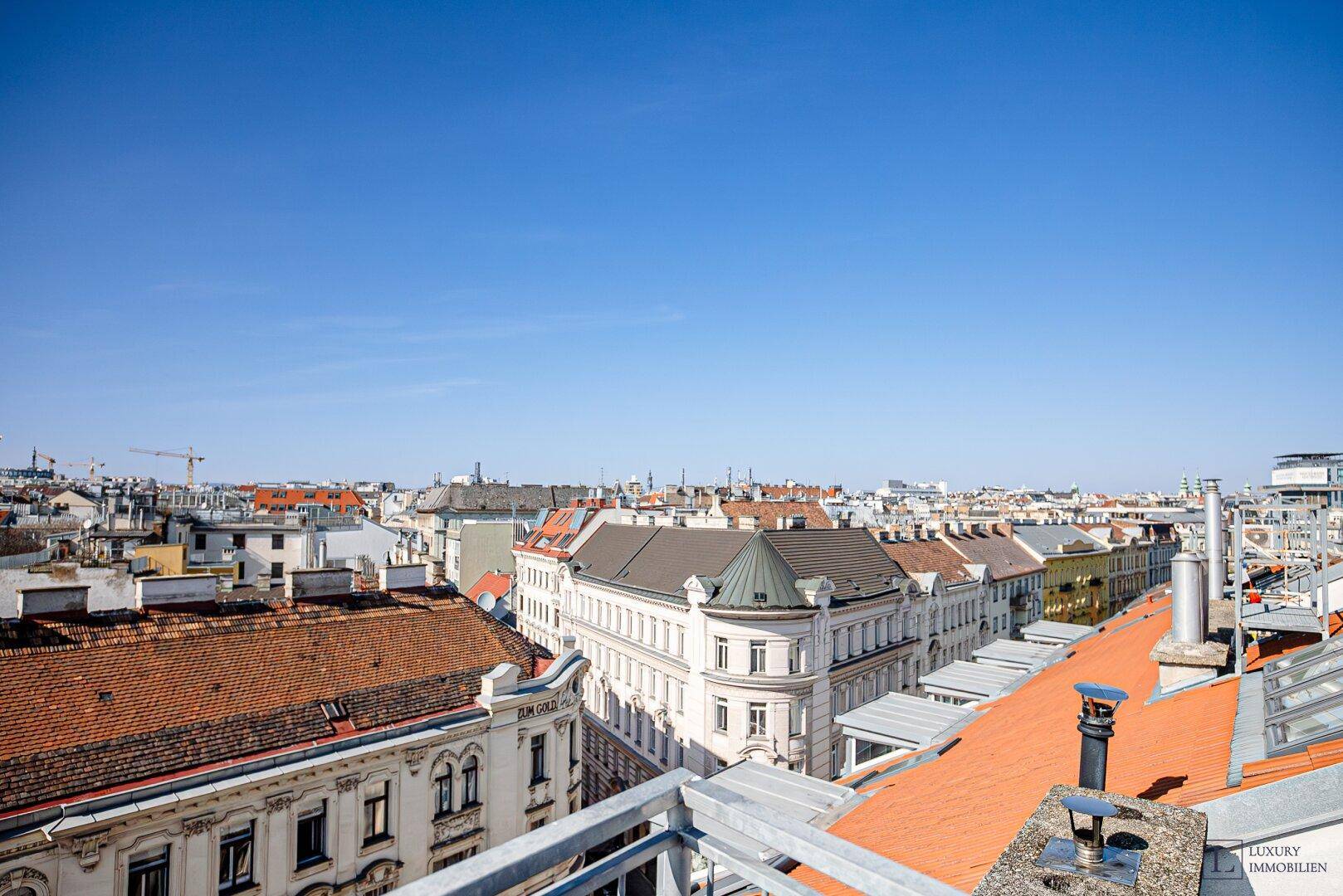 Panoramablick über die Dächer der Stadt mit historischer Architektur und weitem Horizont.