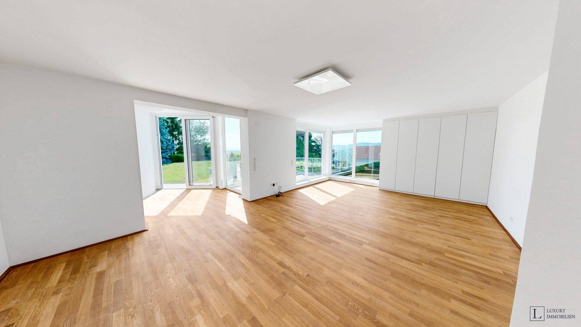 Geräumiges Schlafzimmer mit Holzboden, Einbauschränken und großen Fenstern mit Weitblick.