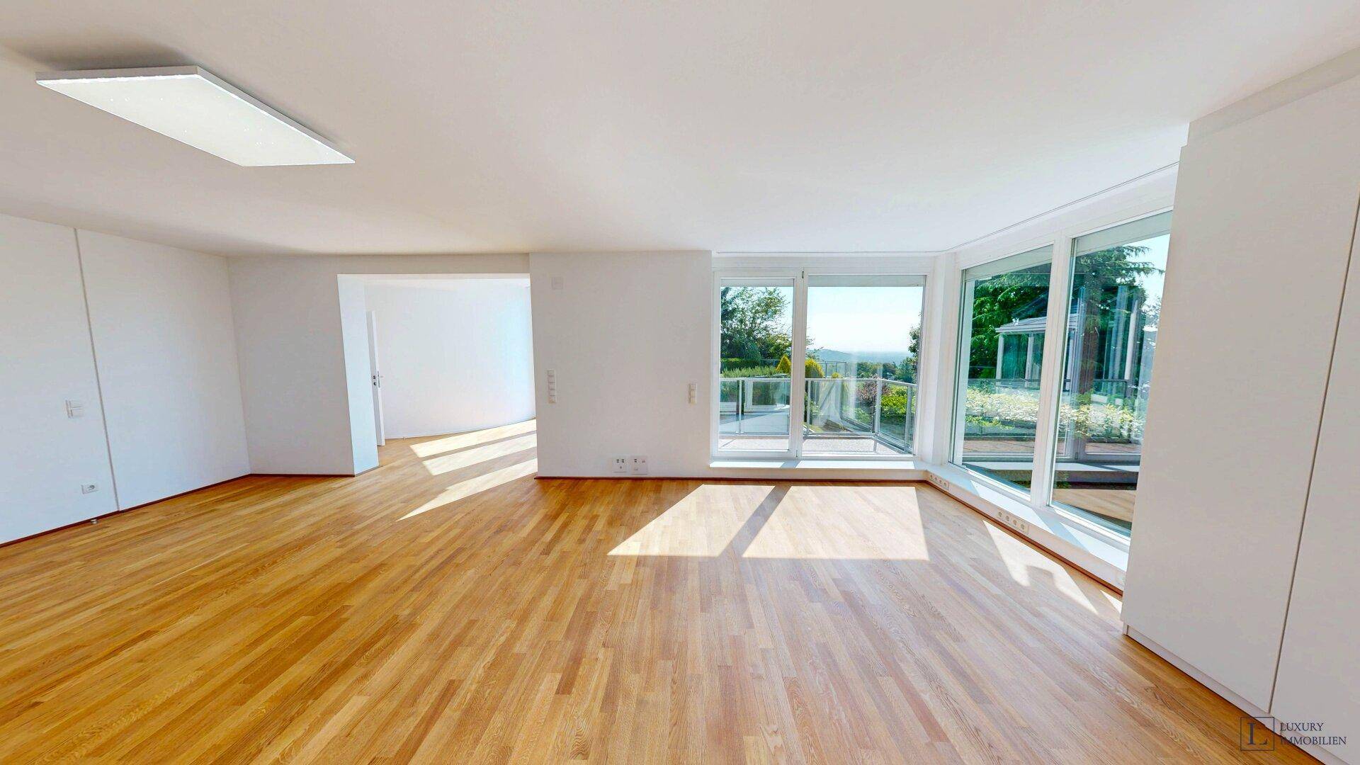 Helles Schlafzimmer mit Holzboden, Einbauschränken und Zugang zu einem Balkon oder einer Terrasse.