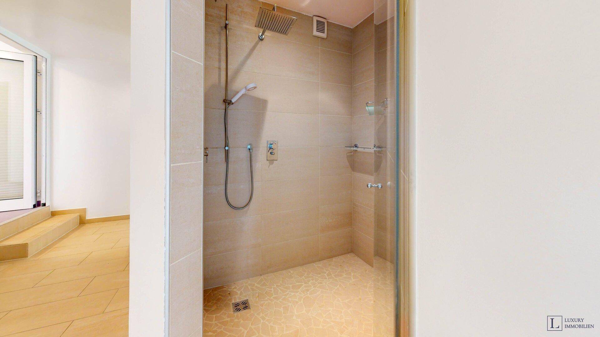 Moderne Dusche mit großformatigen Fliesen, Regendusche und minimalistischem Design.
