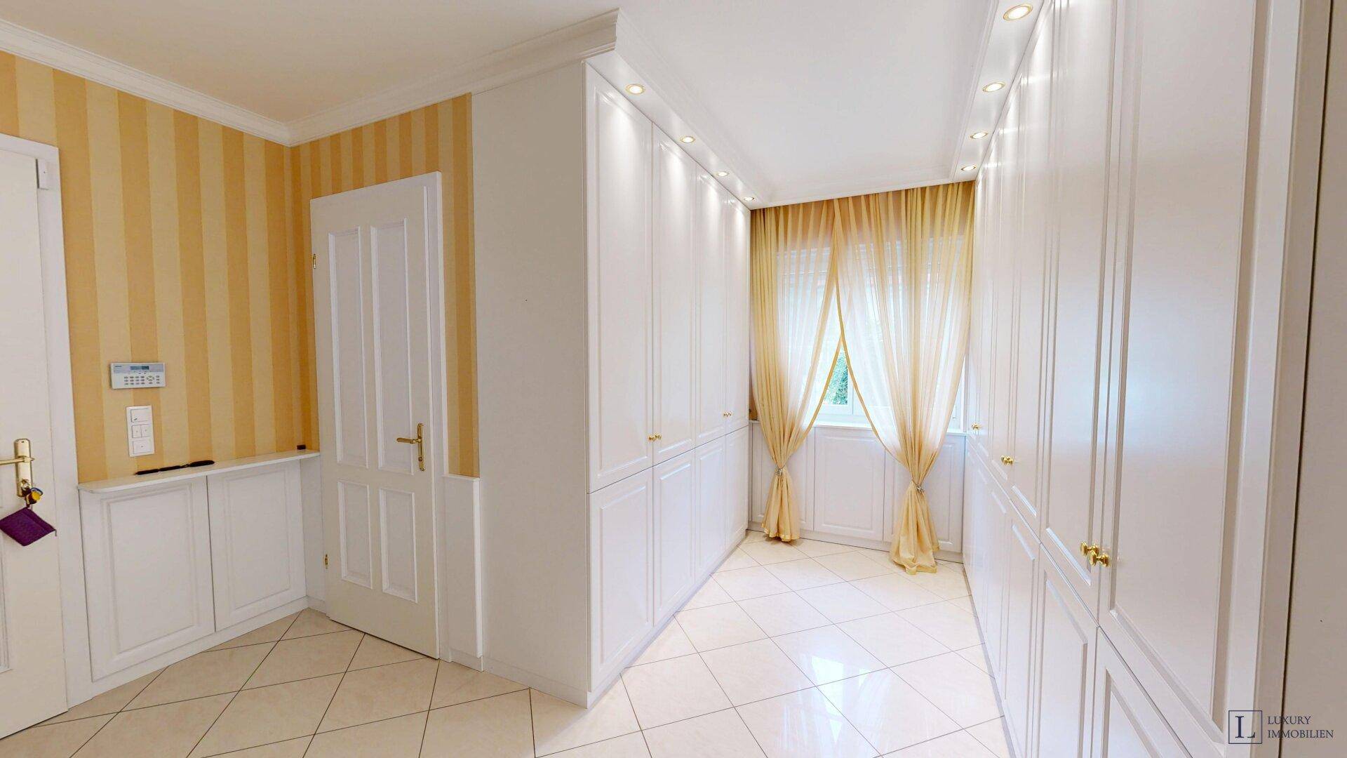 Heller Flur mit Einbauschränken und Fenster, ideal als Ankleidebereich nutzbar.