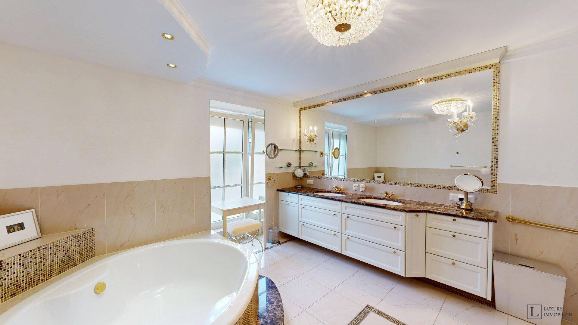 Elegantes Badezimmer mit großem Spiegel, Doppelwaschbecken und runder Badewanne.