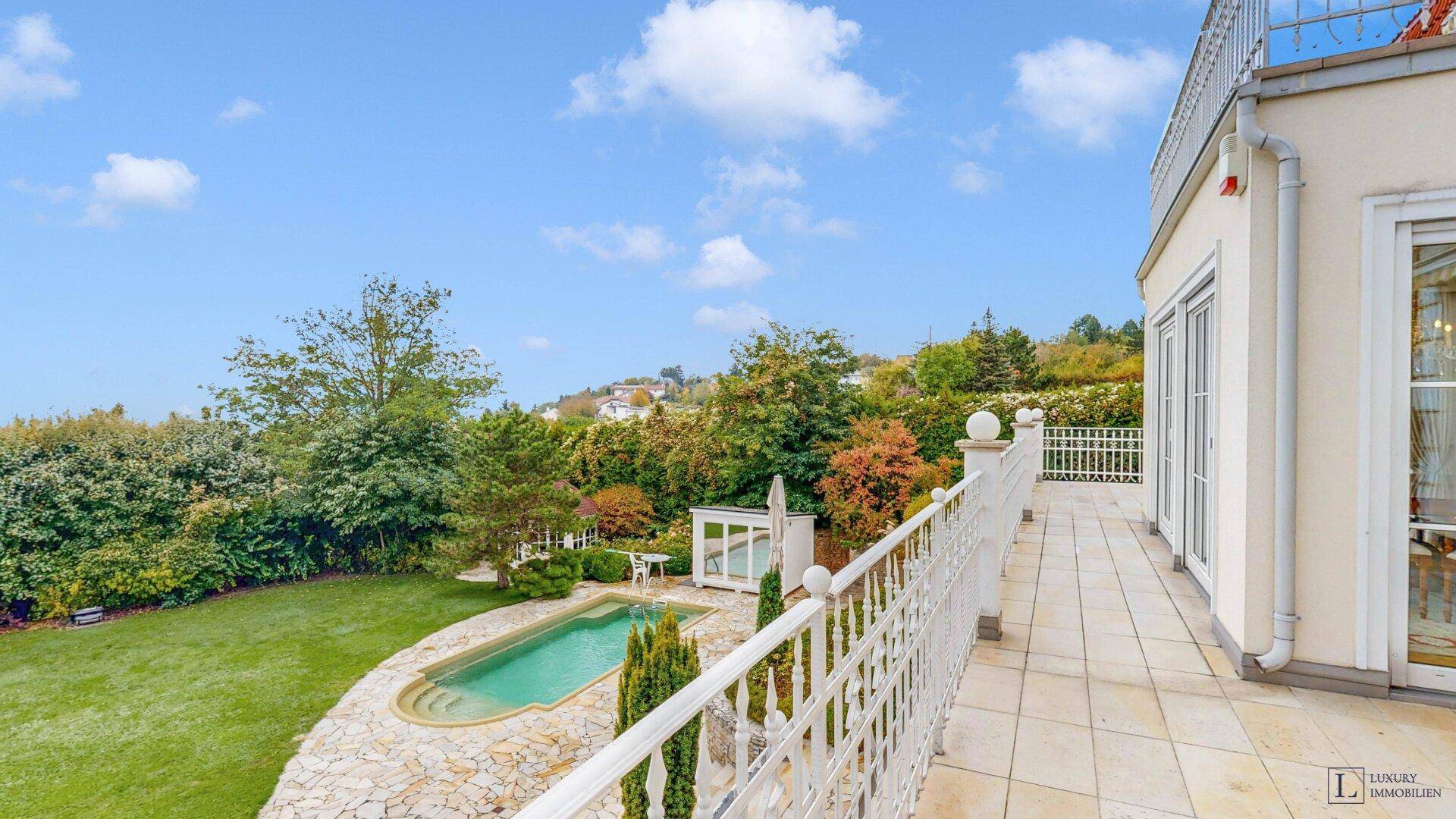 Terrasse mit Blick auf den Garten, den Pool und die umliegende grüne Landschaft.