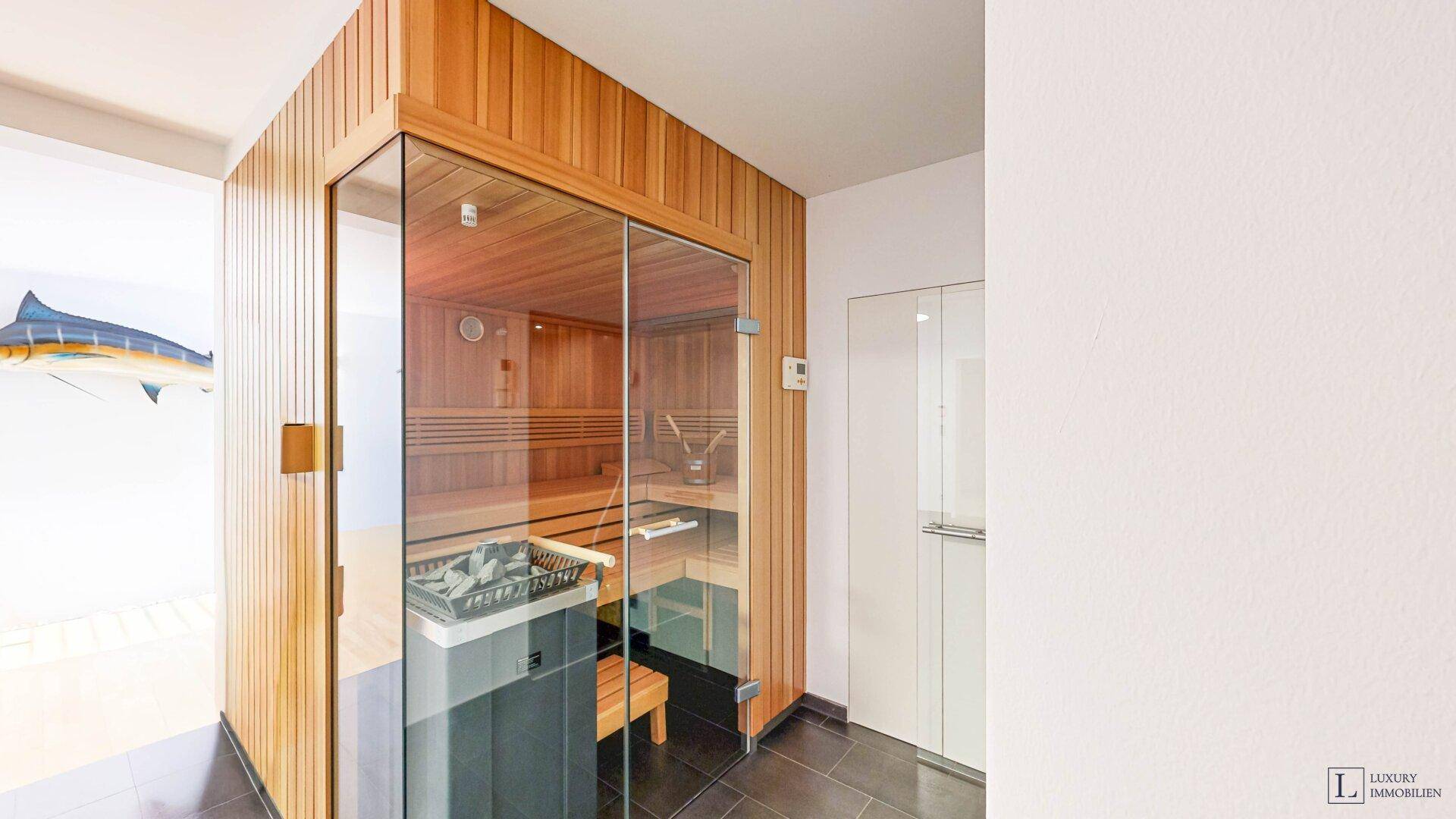 Moderne Holzsauna mit Glasfront und traditionellem Saunaofen.