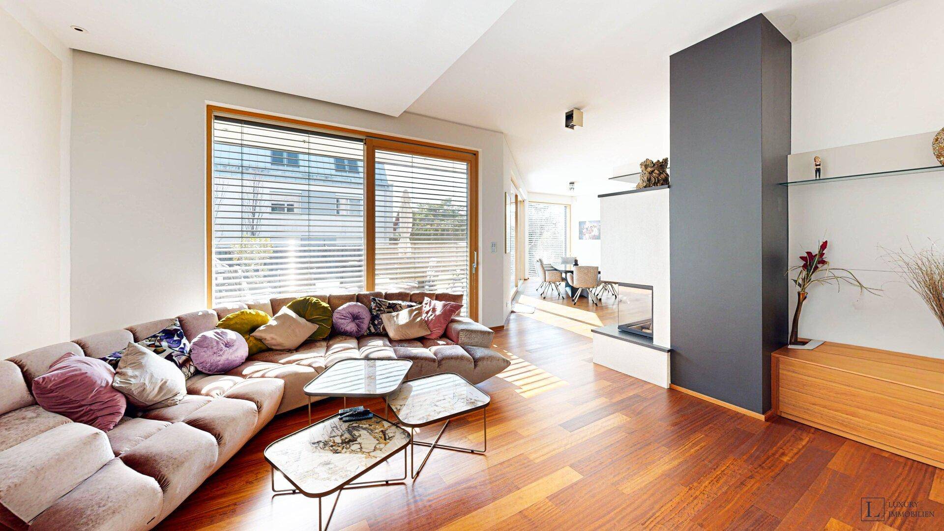 Gemütliches Wohnzimmer mit großem Sofa, Holzboden und Zugang zur Terrasse.