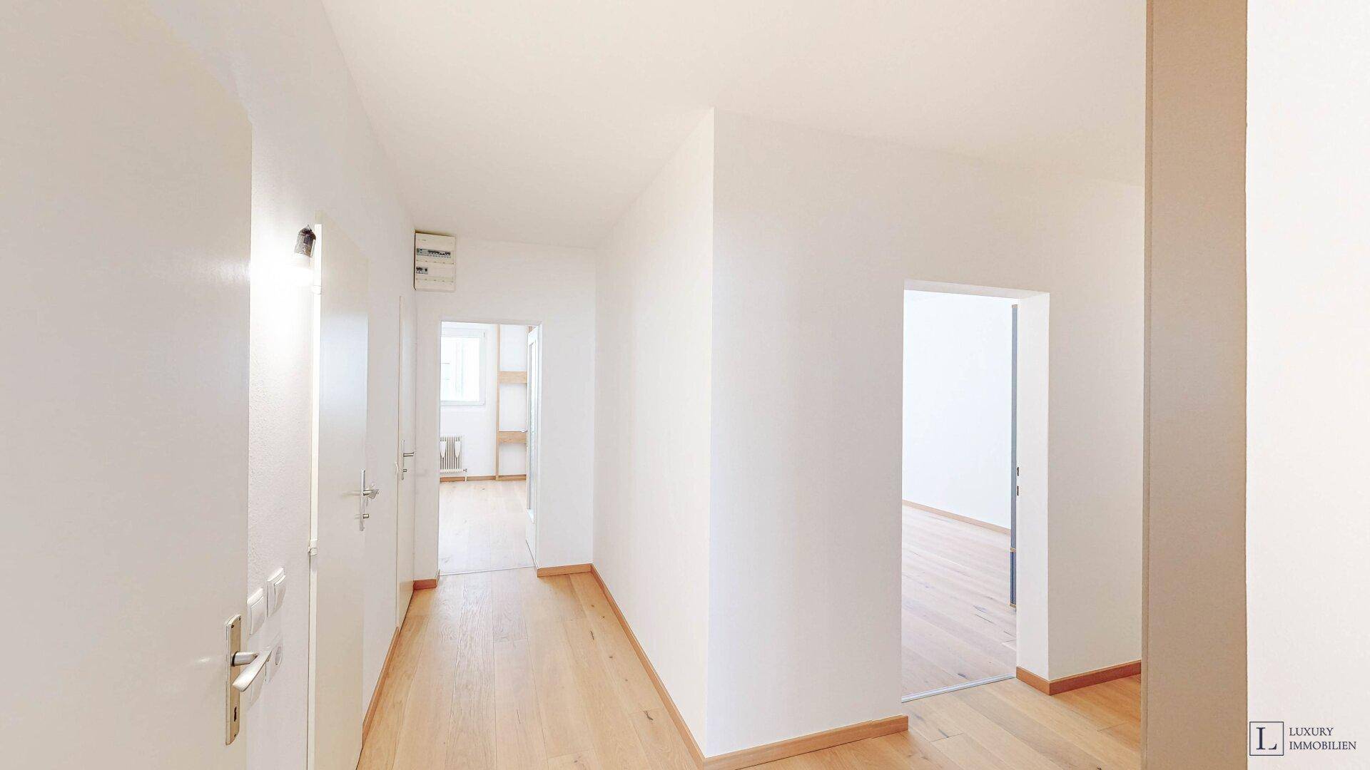 Langer, heller Flur mit mehreren Türen, die zu den verschiedenen Zimmern der Wohnung führen.