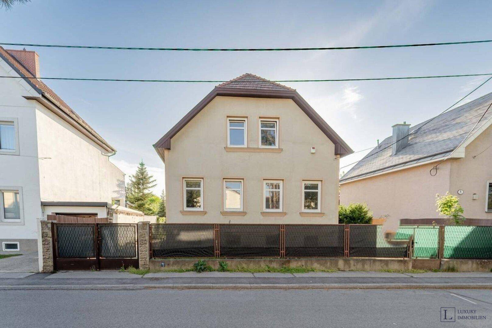 Vorderansicht eines Einfamilienhauses mit Satteldach und gepflegter Fassade von der Straße aus.