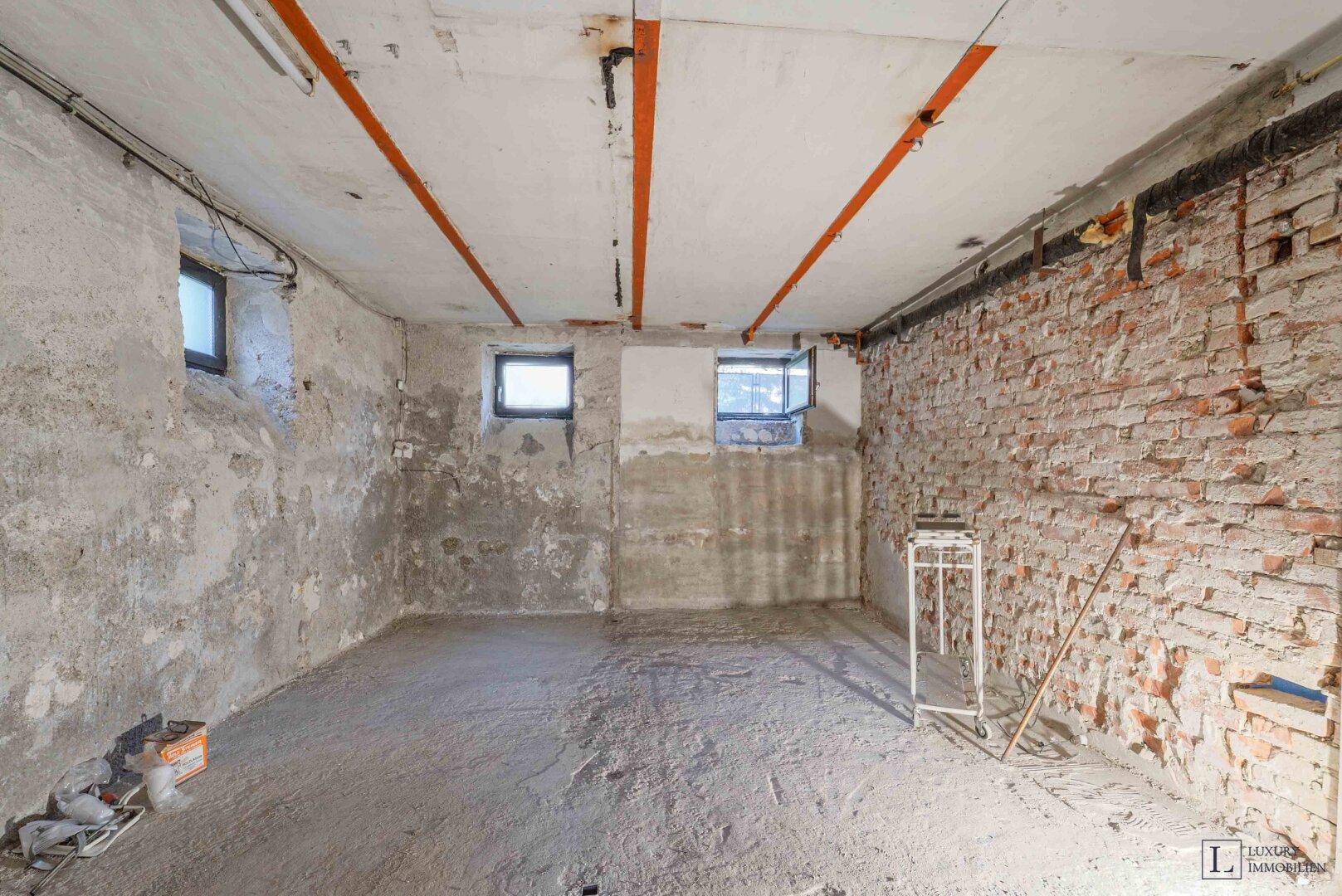 Unausgebauter Kellerraum mit unverputzten Ziegelwänden und Betonboden, bereit für den Ausbau.