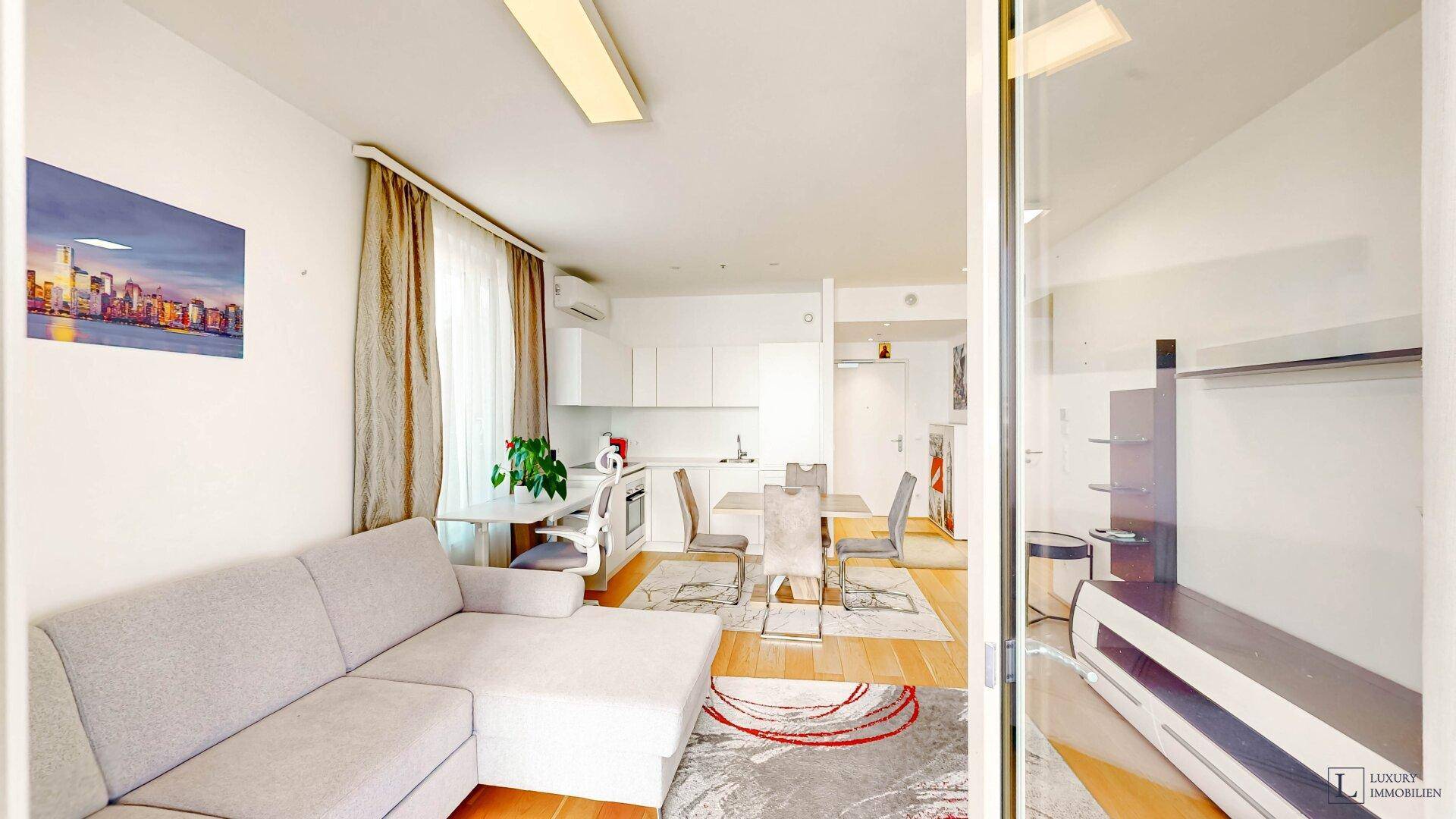 Geräumiger Wohn-Essbereich mit Sofa, Esstisch und moderner Küche, hell und offen gestaltet.