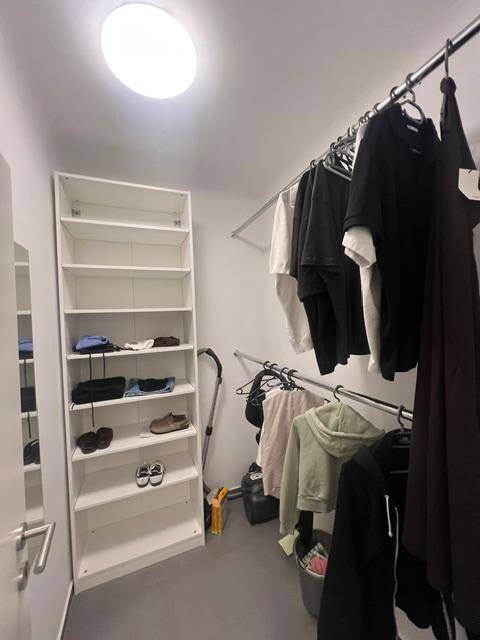 Praktischer begehbarer Kleiderschrank mit Regalen und Kleiderstangen für viel Stauraum.