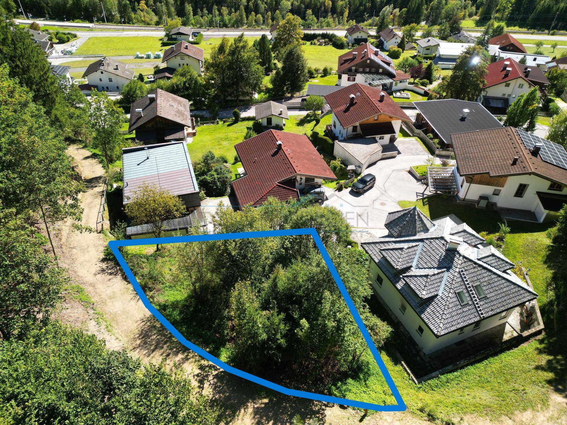Übersicht des Baugrundstücks aus der Vogelperspektive, eingebettet in eine Wohnsiedlung mit weiteren Häusern.