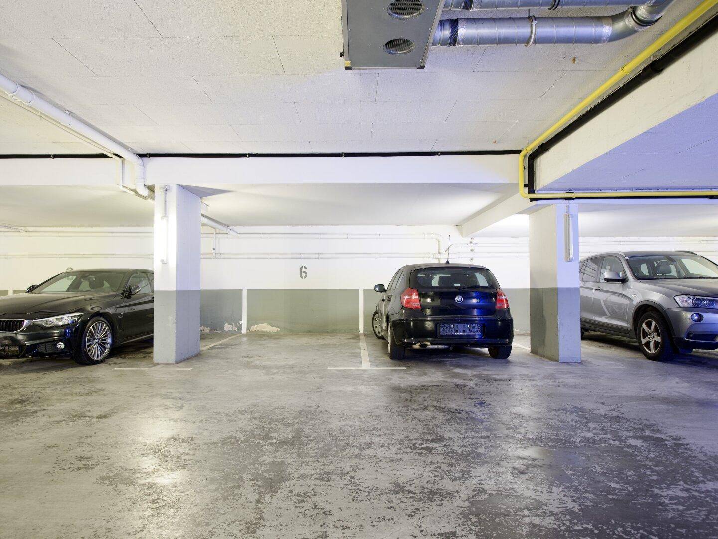 Tiefgarage mit mehreren Stellplätzen und Betonboden.