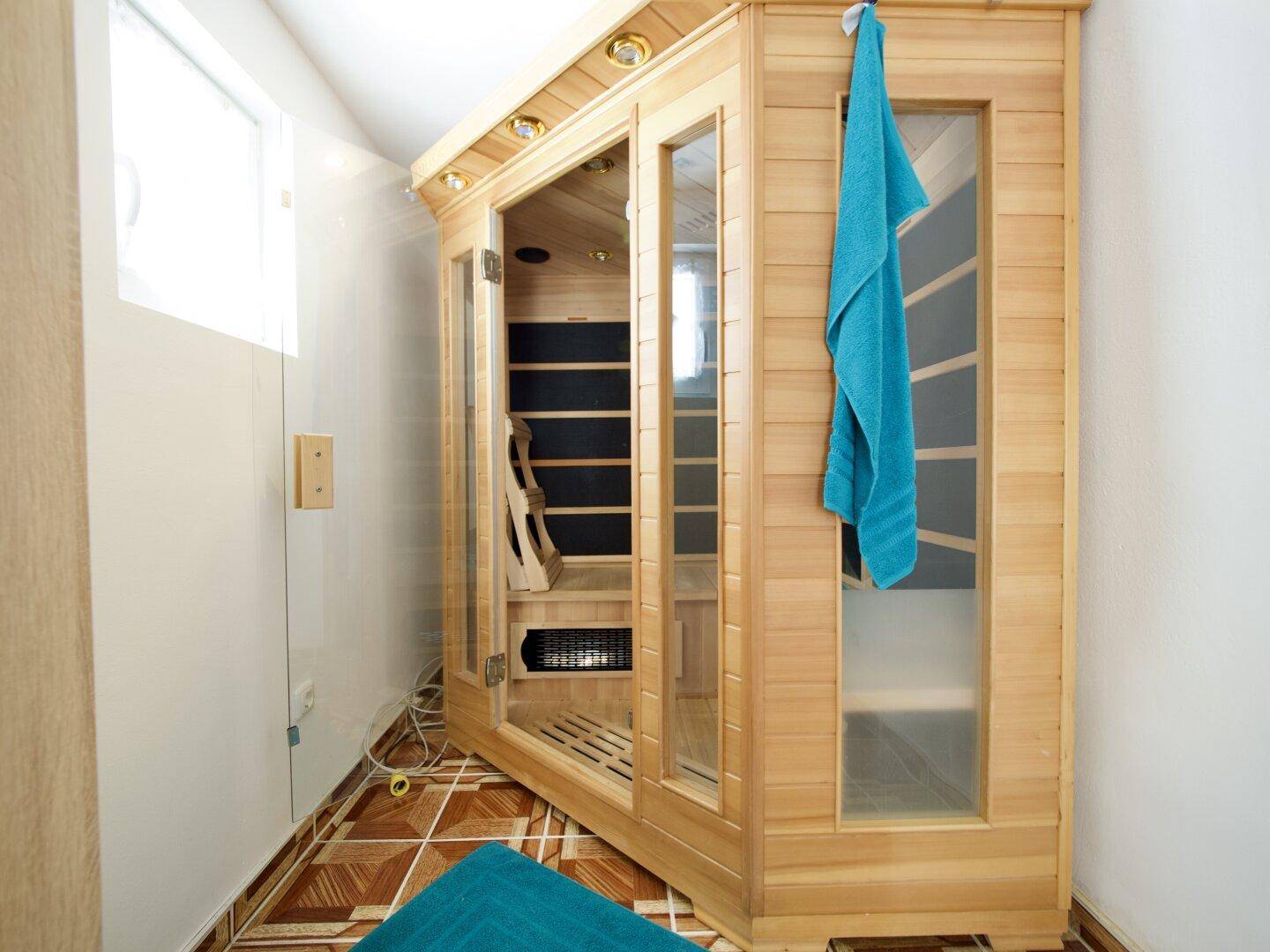 Eine moderne Infrarotsauna in einem kleinen Raum mit Fliesenboden.