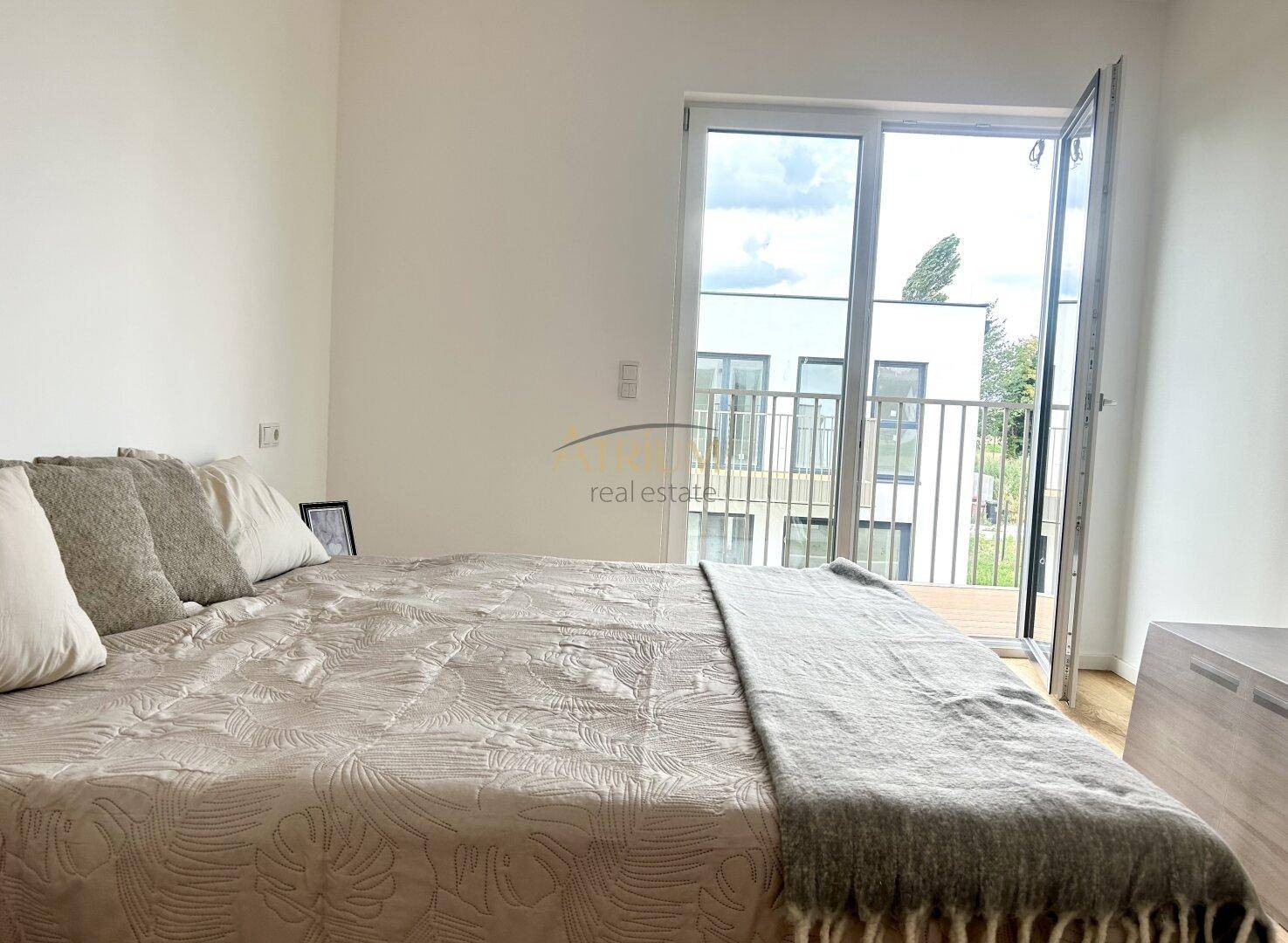 Schlafzimmer mit Doppelbett und direktem Zugang zu einem Balkon.