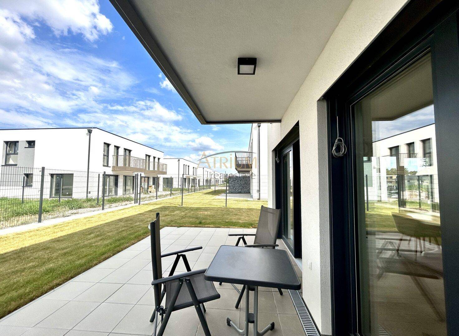 Gemütliche Terrasse mit Sitzgelegenheiten und Blick auf den Gemeinschaftsgarten.