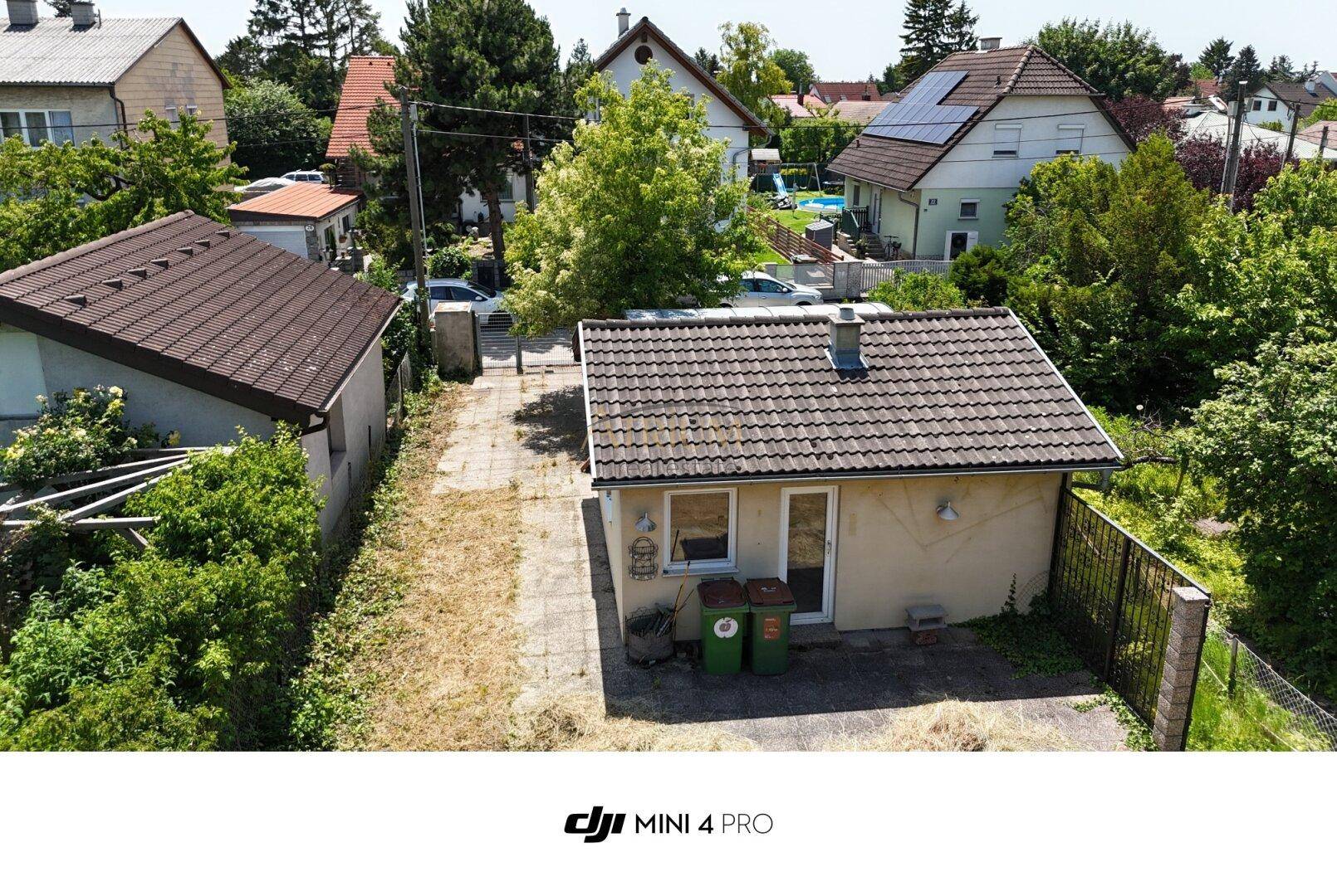 Luftaufnahme des kleinen Hauses mit Zufahrt und benachbarten Gebäuden in ländlicher Umgebung.