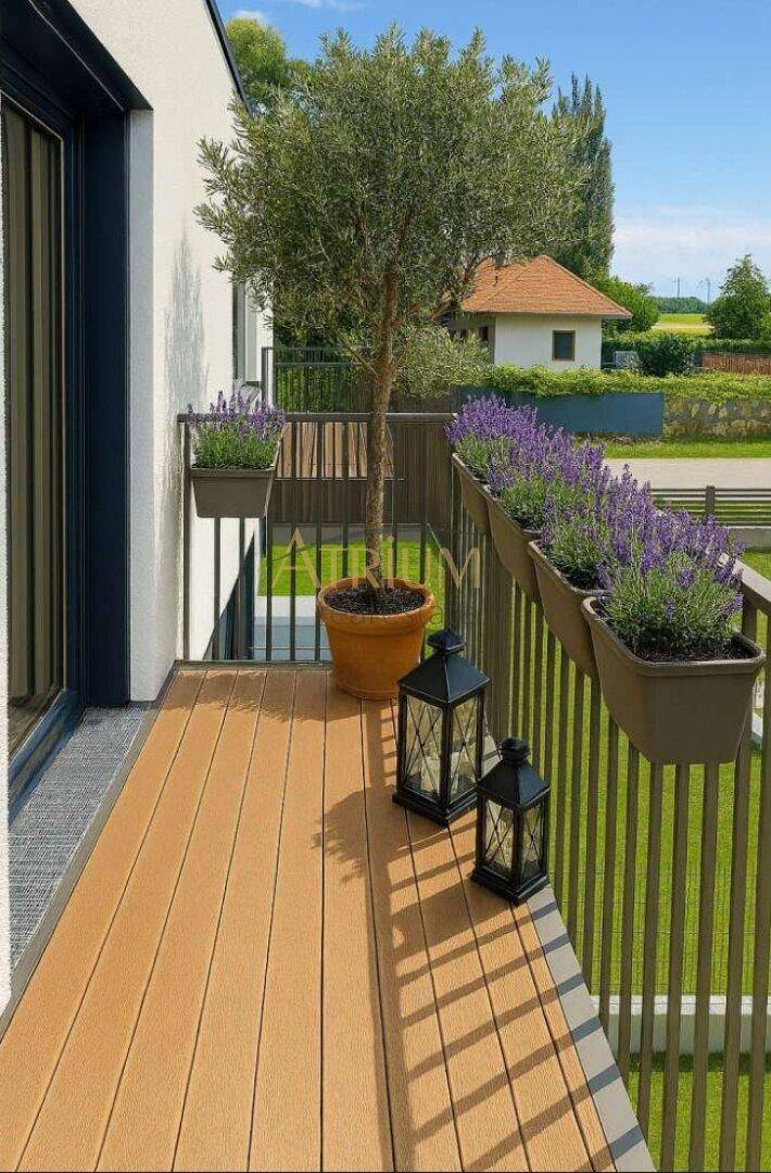 Gemütlicher Balkon mit Holzboden, Olivenbaum und Lavendelpflanzen.
