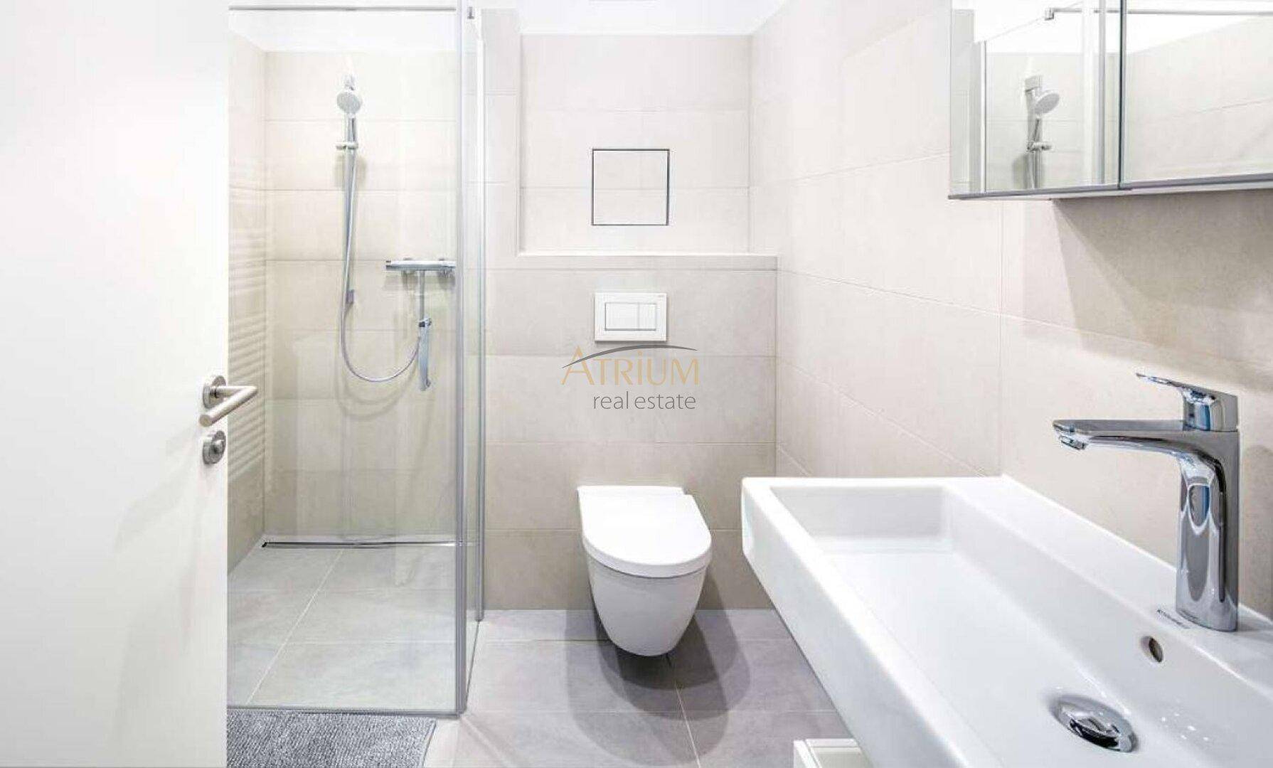 Modernes Badezimmer mit ebenerdiger Dusche, Wand-WC und großformatigen hellen Fliesen.