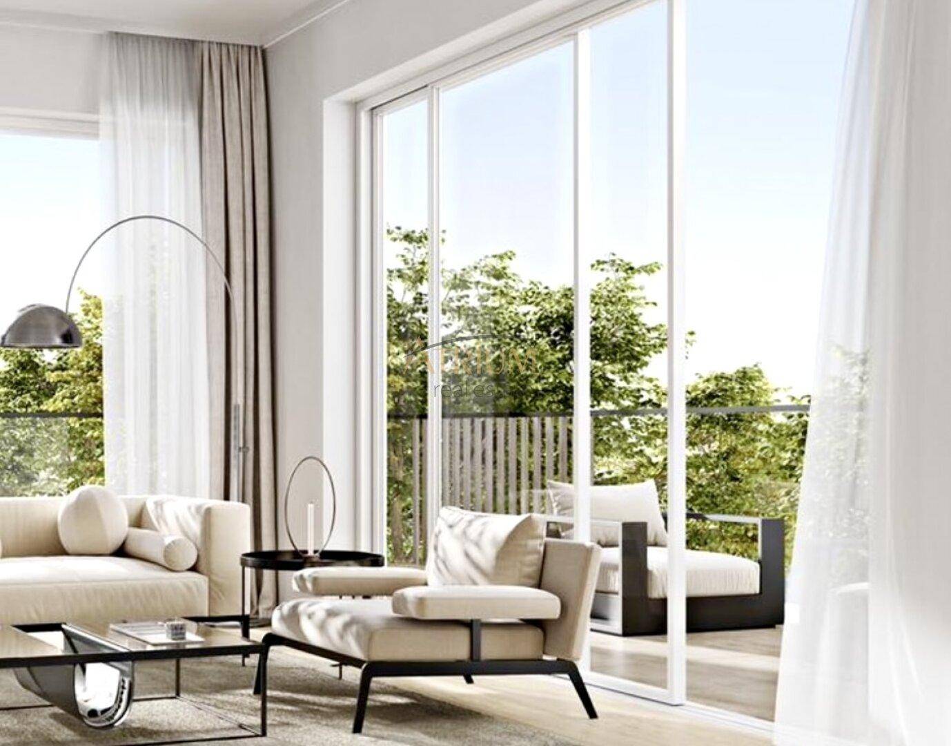 Helles Wohnzimmer mit großen Schiebetüren, die auf einen Balkon mit Grünblick führen.