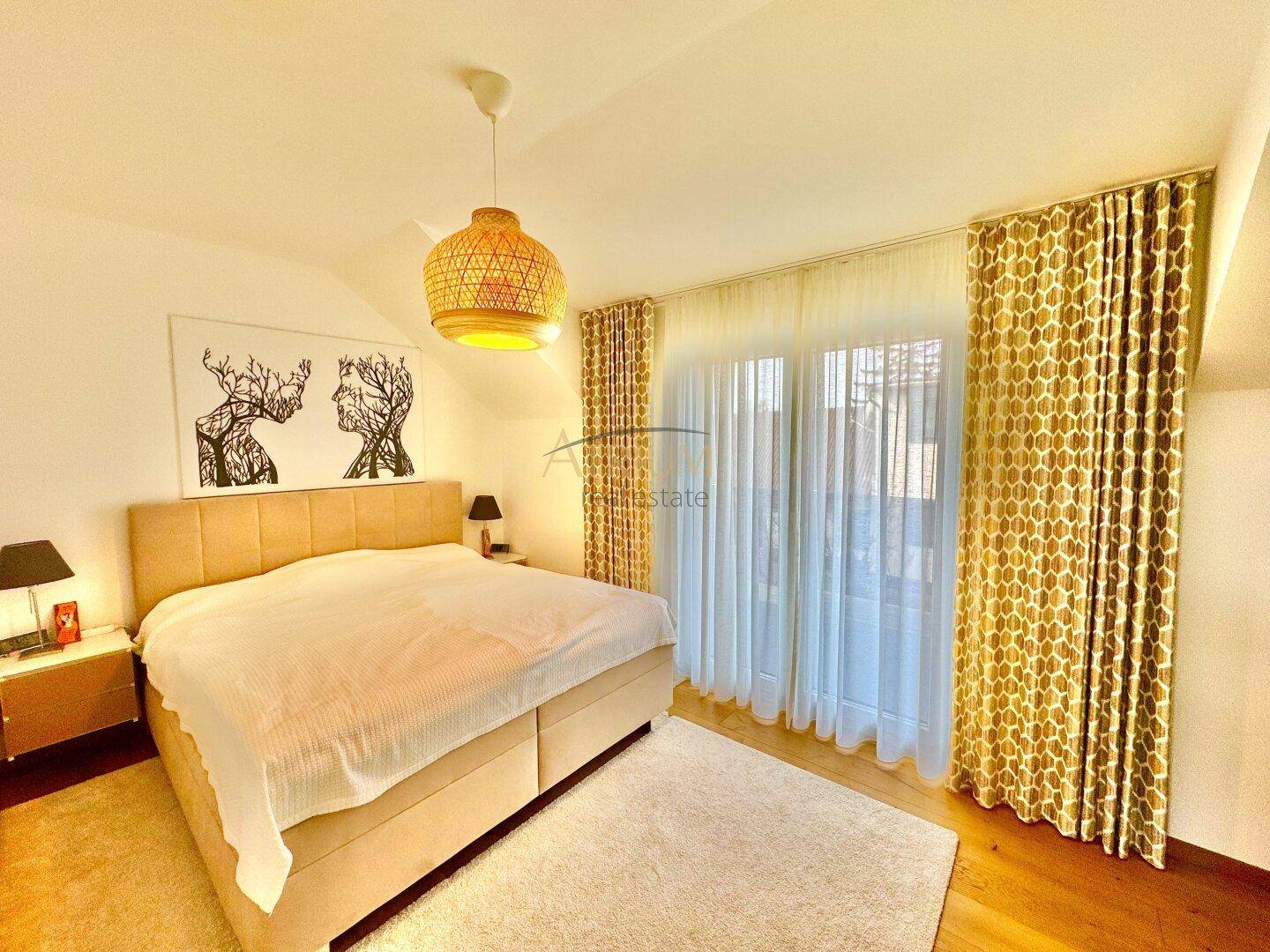 Gemütliches Schlafzimmer mit Doppelbett, Holzboden und Zugang zu einem Balkon.