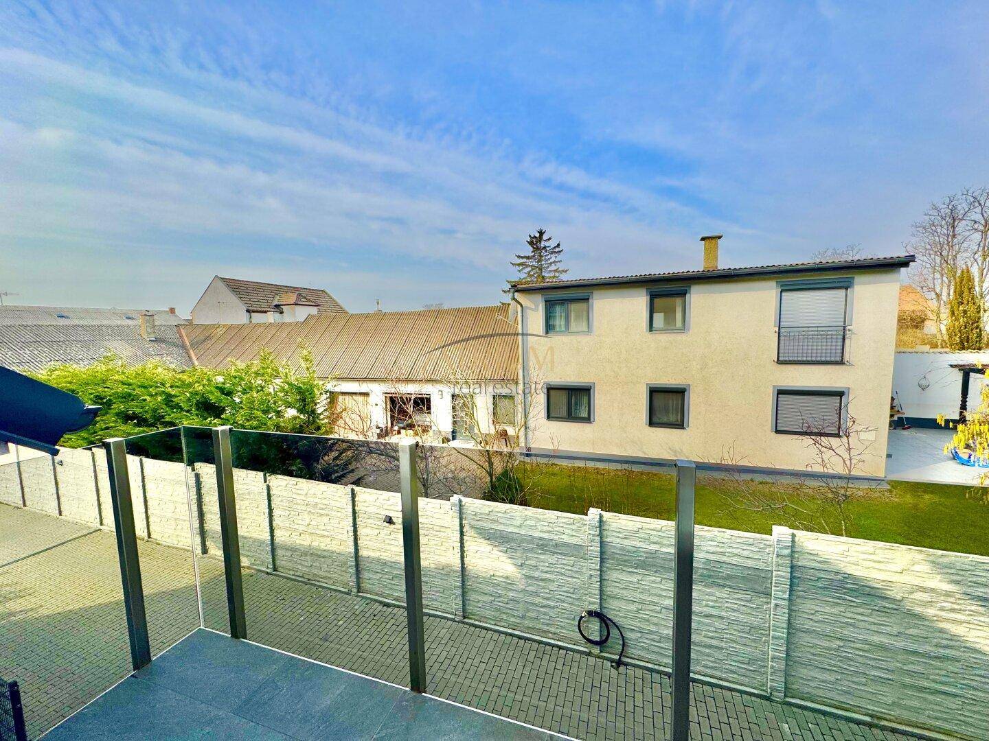 Blick von der Terrasse auf den Garten und die umliegenden Gebäude.
