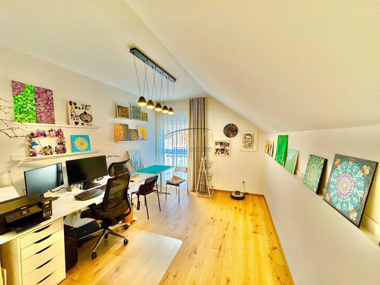 Geräumiges Arbeitszimmer im Dachgeschoss mit Holzboden und viel Tageslicht.