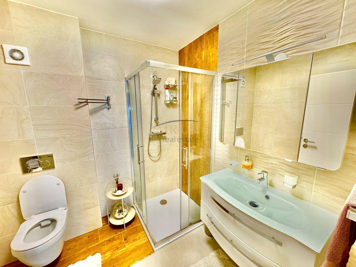 Helles Badezimmer mit Duschkabine, WC und modernem Waschtisch.