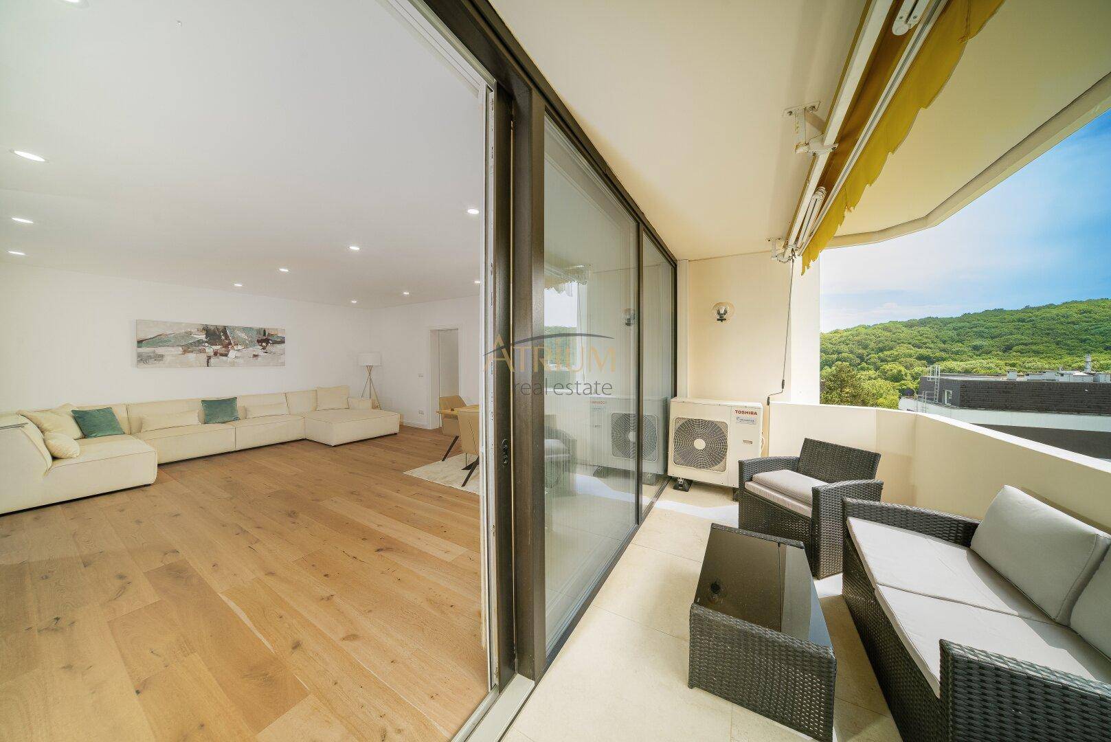 Geräumiger Balkon mit bequemen Outdoor-Möbeln und weitem Blick ins Grüne.