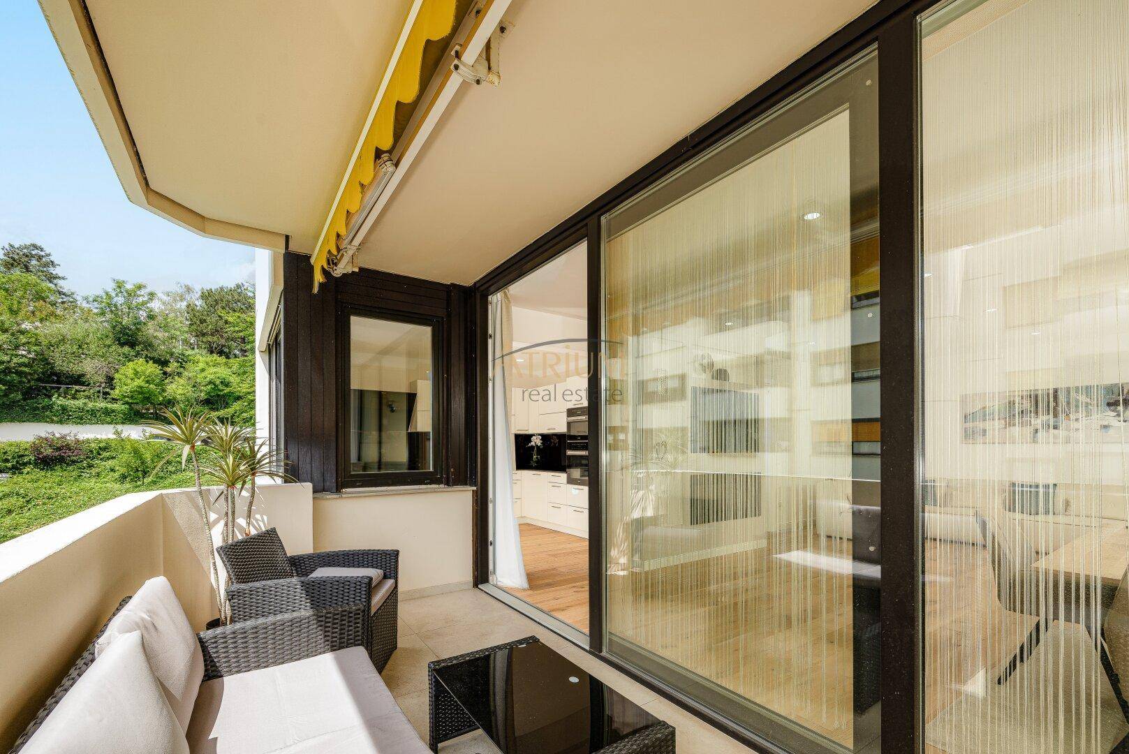 Heller Balkon mit Sitzgelegenheiten und Blick auf die Umgebung sowie die moderne Küche.