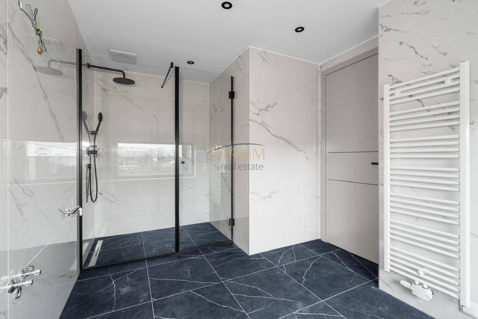 Modernes Badezimmer mit begehbarer Dusche, Marmoroptik-Fliesen und beheiztem Handtuchhalter.