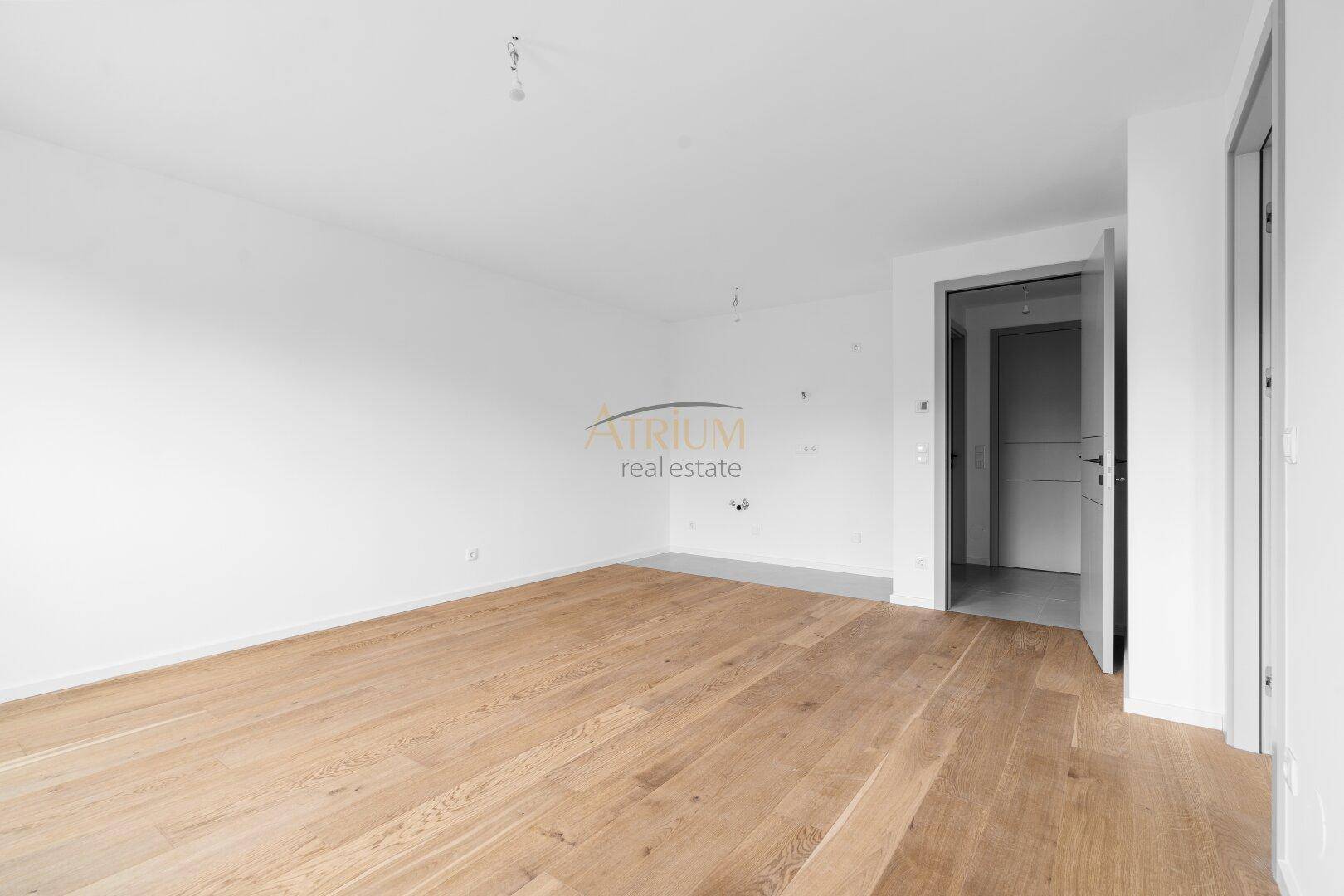 Unmöbliertes Zimmer mit Holzboden und weißen Wänden, ideal für ein Schlaf- oder Wohnzimmer.