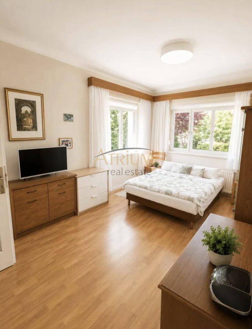 Helles Schlafzimmer mit Doppelbett, Holzmöbeln und großen Fenstern für viel Tageslicht.