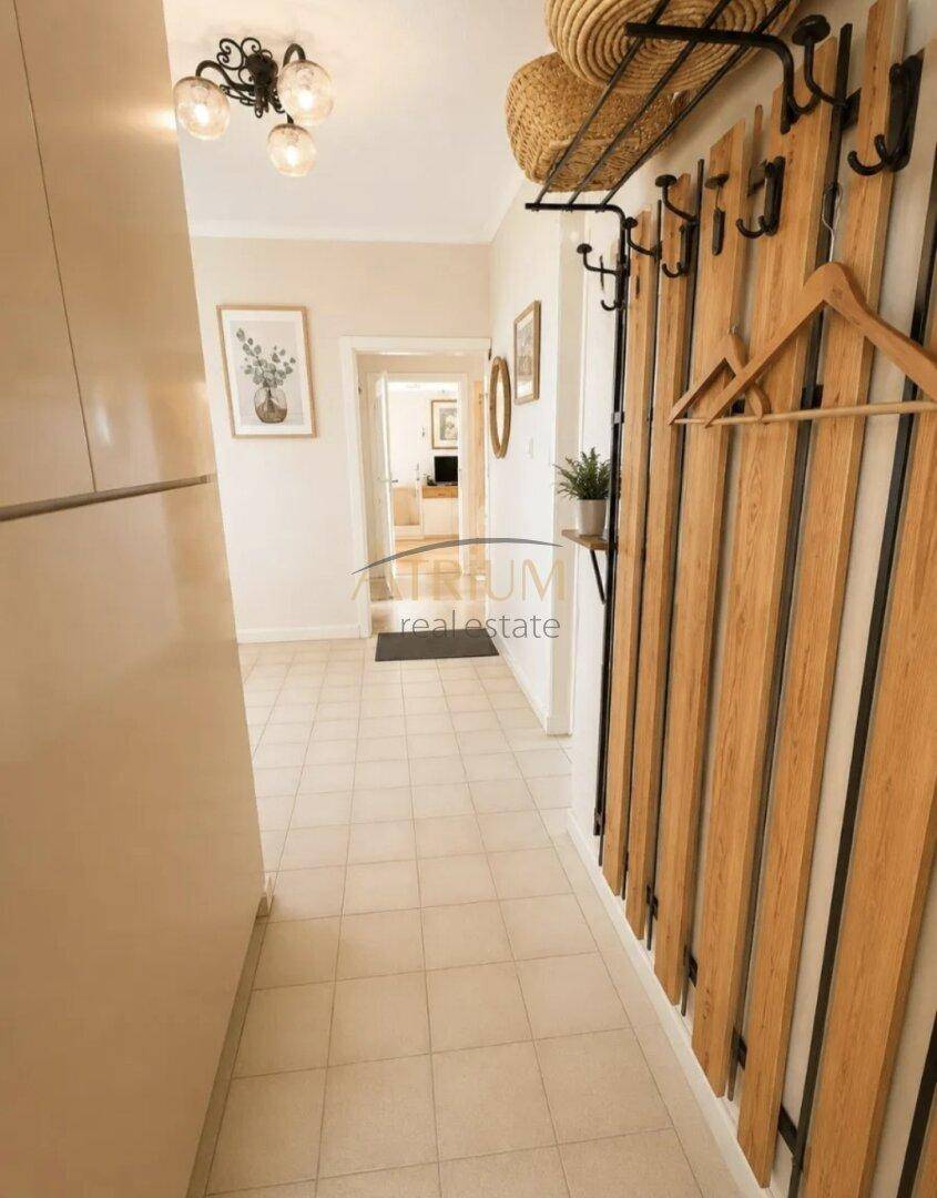 Langer Flur mit gefliestem Boden, moderner Garderobe und hellem Ambiente.