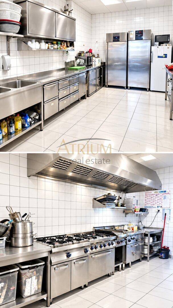 Professionelle Großküche mit Edelstahlgeräten, Fliesenwänden und umfangreicher Ausstattung.