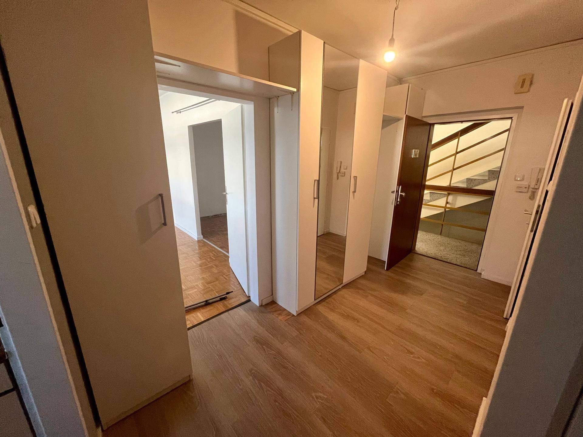 Geräumiger Flur mit Spiegelschränken und Blick auf das Treppenhaus, bietet viel Stauraum.