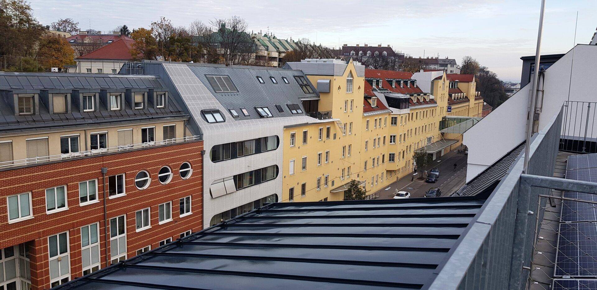 Blick über Dächer und Gebäude einer städtischen Umgebung mit verschiedenen Architekturstilen.