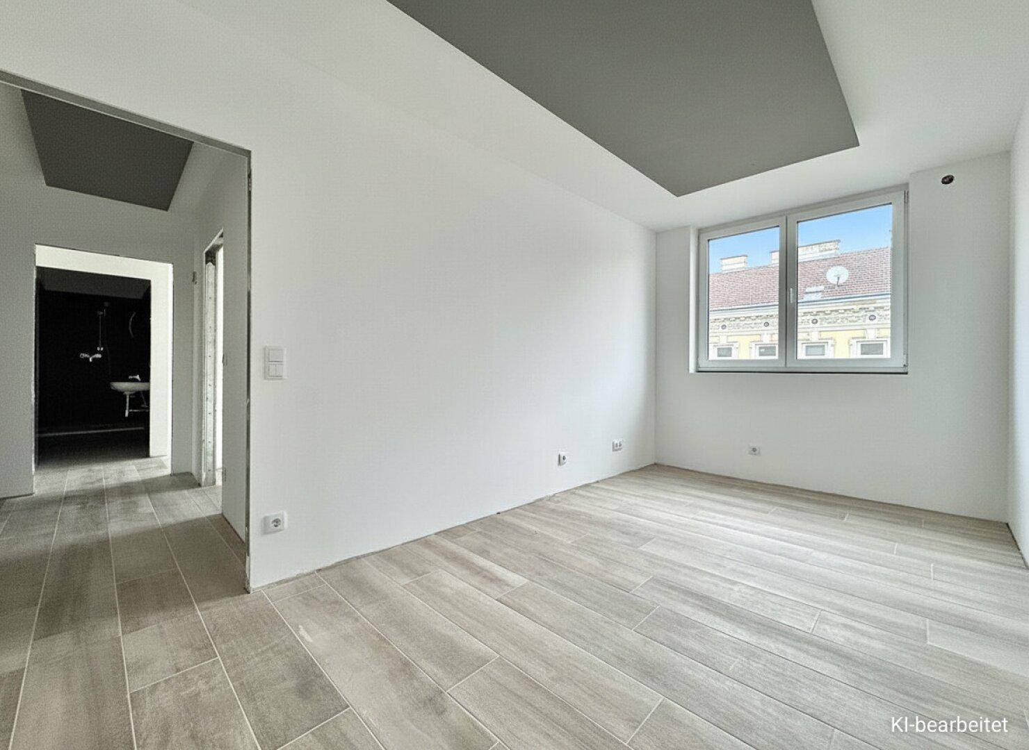 Heller Raum mit Holzfliesenboden und Blick auf die Stadt, angrenzend an ein Badezimmer.