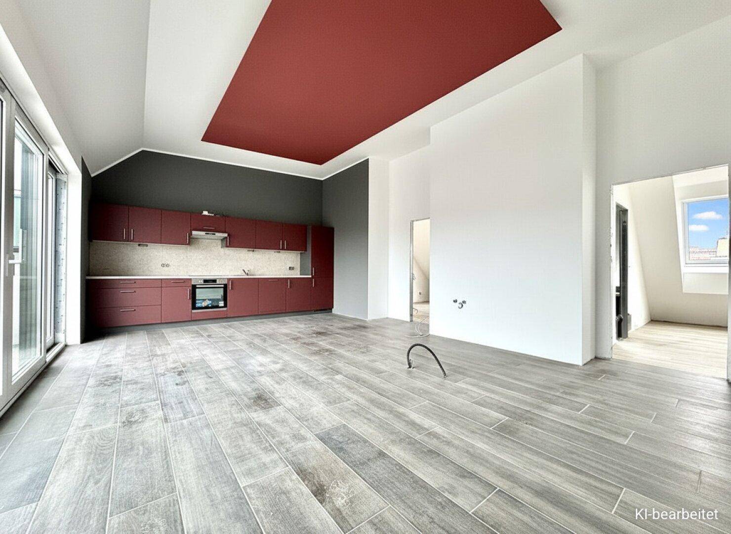 Heller offener Wohnbereich mit moderner Einbauküche, roten Akzenten und Zugang zum Balkon.