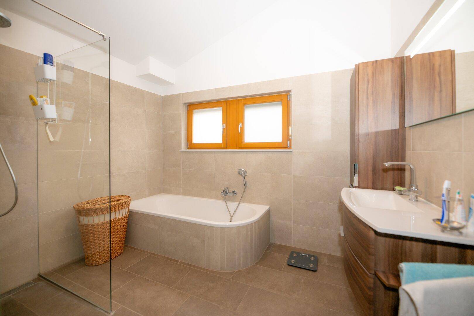 Helles Badezimmer mit Eckbadewanne, Duschbereich und modernem Waschtisch.