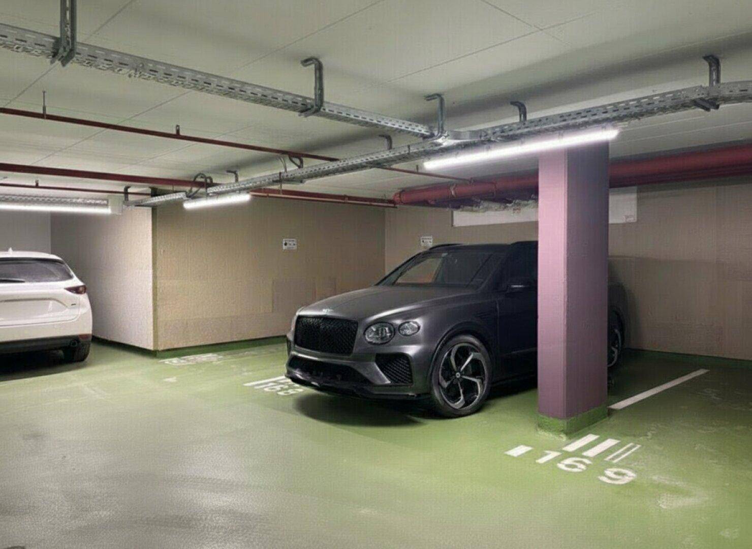 Helle Tiefgarage mit mehreren Stellplätzen und modernen Fahrzeugen in sauberer Umgebung.